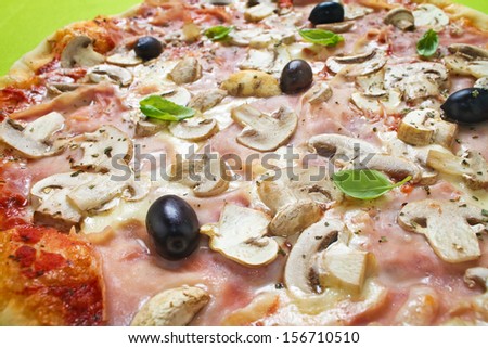 Rustic thin crust pizza with pelato sauce, mozzarella, ham, mushrooms, olives and fresh basil