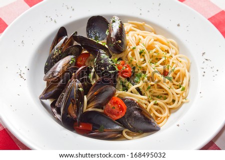 Mussels and spaghetti in marinara sauce with cherry tomato and parsley