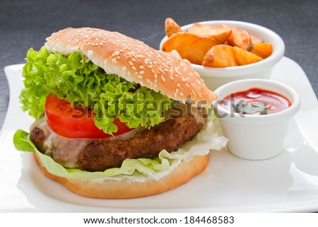 Homemade cheeseburger ketchup and potato wedges on restaurant table
