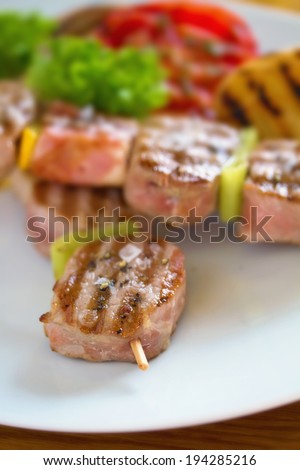Juicy Pork tenderloin on a bamboo stick or skewer ready to be eaten. See more from grill