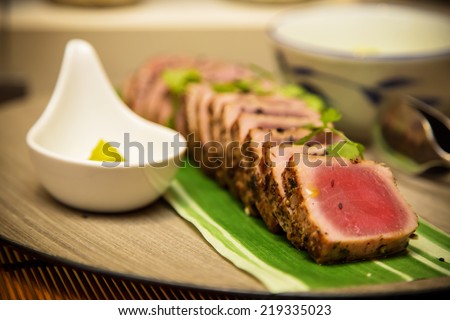Seared tuna steak called Sashimi traditional Japanese dish with wasabi sauce on side