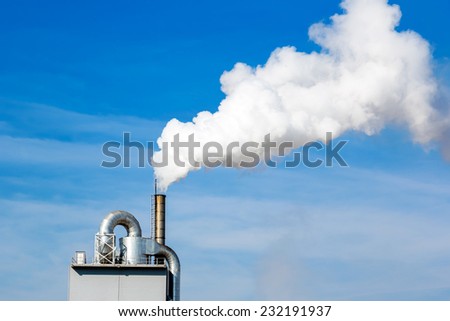 A close-up factory chimney smoking