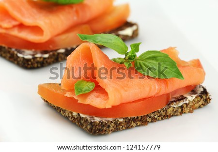 Delicious canape with smoked salmon, tomatoes and fresh basil