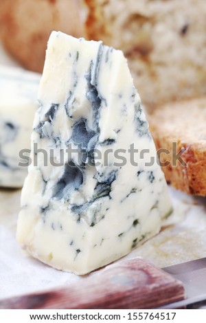 Wedge of French blue Roquefort cheese with rustic homemade freshly baked loaf of walnut bread