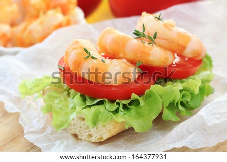 Delicious fresh shrimp sandwich with green lettuce leaves and tomatoes