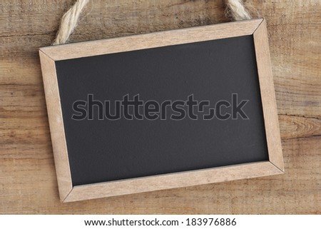 Vintage blackboard hanging on a wooden background with copy space Vintage blackboard hanging on a wooden background with copy space