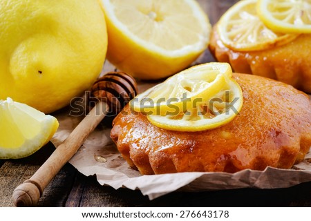 Aromatic homemade lemon cake with honey decorated with grilled lemon slices in rustic wooden table