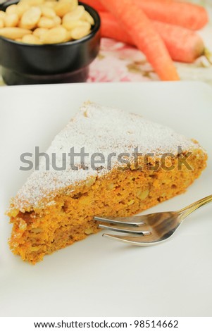 A piece of almond and carrot cake topped with powdered sugar