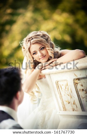 The bride on a background of nature listens playing the piano