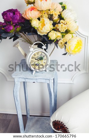 Interior in retro style: clock, chair and bouquet of flowers