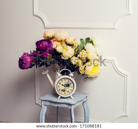 Spring time. Old fashion alarm clock with peonies