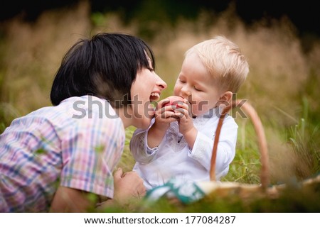 Mom and son eating fruit with wicker baskets