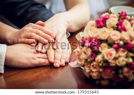 Hands with wedding rings amd bouquet