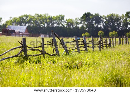 An open farm gate leading to a field