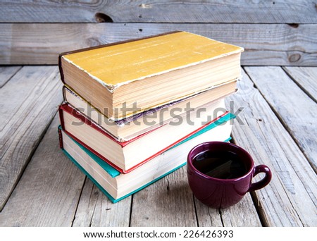 Education and Science. A stack of old books on a wooden background. Vintage book with a cup of coffee on the table.