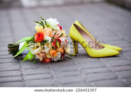 Beautiful wedding bouquet of roses and peonies on the pavement. Stylish and fashionable shoes bride yellow. Lemon yellow wedding. belt tiles. delicate flowers