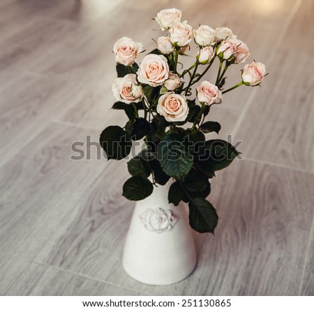 flowers. Beautiful bouquet of peach roses in vintage vase on a black background