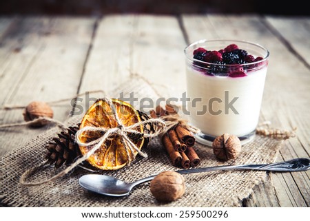 Serving of frozen creamy ice yoghurt  with whole fresh blueberries and wooden spoon with selective focus. Healthy sweet dessert with organic berries. food, dessert