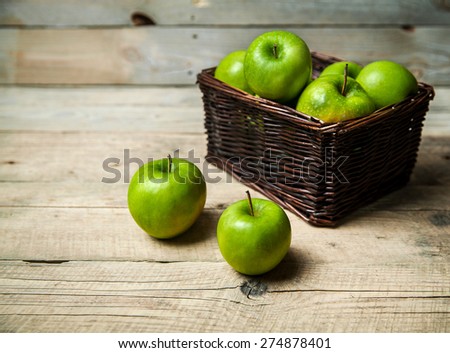 apples in a basket on wooden table