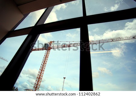 Crane in construction site ,hospital office building windows view.