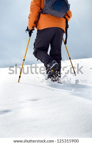 Close up of hiker walking up on a snow-covered slope