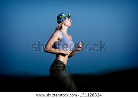 Young woman running in the dark with headlamp outdoor
