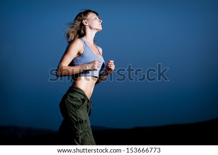 Young woman running in the dark outdoor