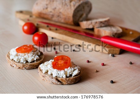Two sandwiches of brown bread with cottage cheese and cherry tomato