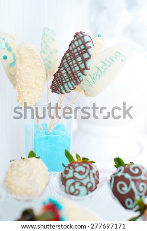 Variety of fruits (strawberry, banana, grape, pineapple) covered with a color chocolate and nuts, decoration of \
wedding party table