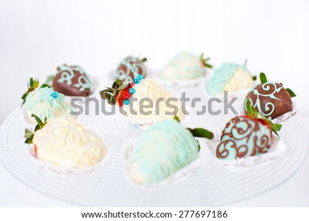 Variety of fruits (strawberry, banana, grape, pineapple) covered with a color chocolate and nuts, decoration of \
birthday or wedding party table
