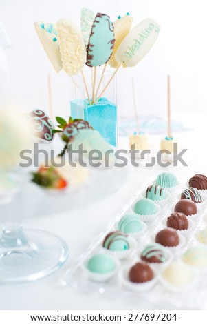 Variety of fruits (strawberry, banana, grape, pineapple) covered with a color chocolate and nuts, decoration of 
birthday or wedding party table