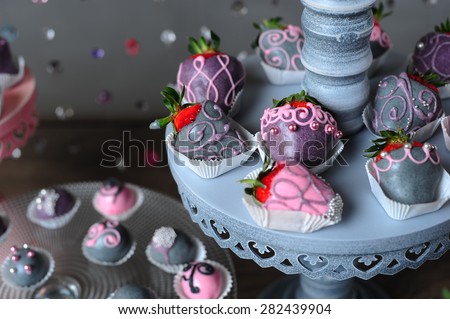 Variety of fruits (strawberry, banana, grape, pineapple) covered with a color chocolate and nuts, decoration of birthday or wedding party table