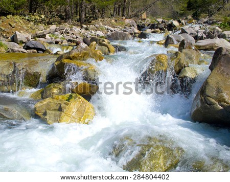 stones and mountain river with small waterfall, blurred background
