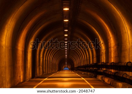 A long single lane tunnel stretches into the distance.