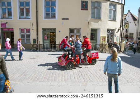 TALLINN, ESTONIA - MAY 1, 2011: Group of young people on the bike in Old Town near Town Hall Square. Old Town is historical center of the city