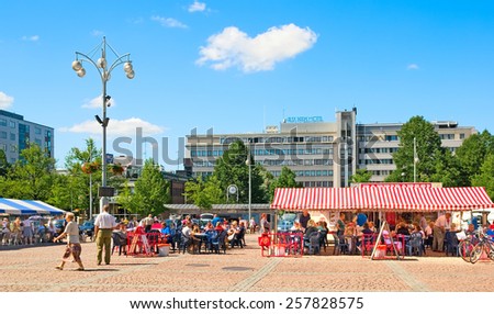 LAHTI, FINLAND - JULY 17, 2010: People rest and eat in cafes on Market Square in the center of Lahti. On the background is Alex Park Hotel