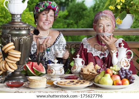 Two mature women from the Victorian era having a cup of tea