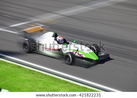 Formula 2.0  race car racing on speed track with motion blur at summer day