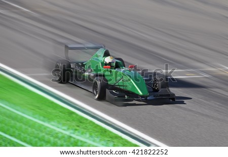 Formula 2.0  race car on speed track with motion blur at sunny day