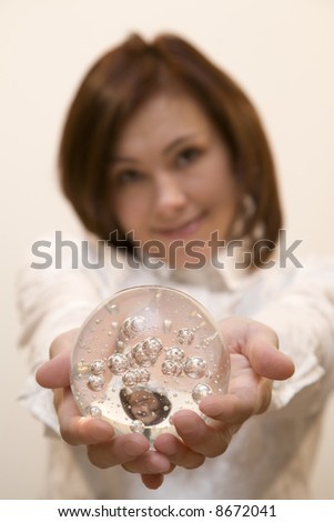 Young woman holds a glasses ball in her hands