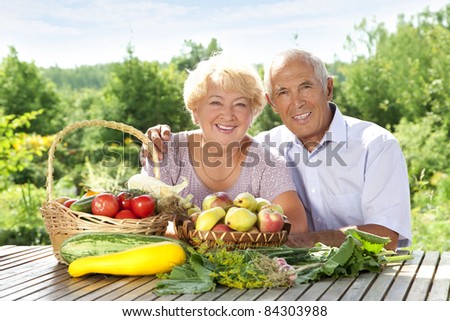 Happy elderly couple with this year\'s rich harvest