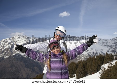 Mother and daughter posing happily against mountains