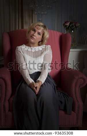 Elegantly young woman posing on an antique chair