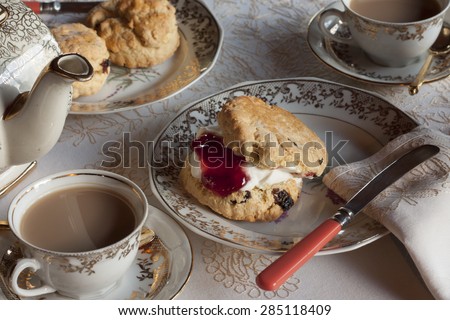 Tea and scones on gold embossed china. Traditional English high tea.