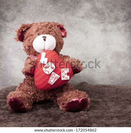 Teddy bear holds in paws heart symbol . For the day of Valentine.