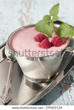 Cocktail of frozen raspberries with yogurt in a metal cup.