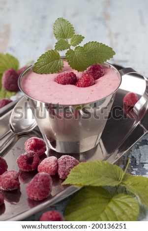Cocktail of frozen raspberries with yogurt in a metal cup.
