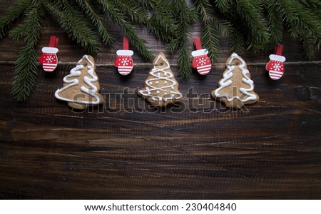 Christmas background with cookies decorated with icing, with clothespins - gloves     on a wooden board.
