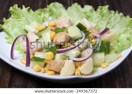 Salad with chicken meat, cucumbers, corn, onions and pasta.