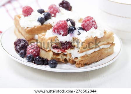 Soft waffles with protein cream, berry jam, whipped cream and berries.